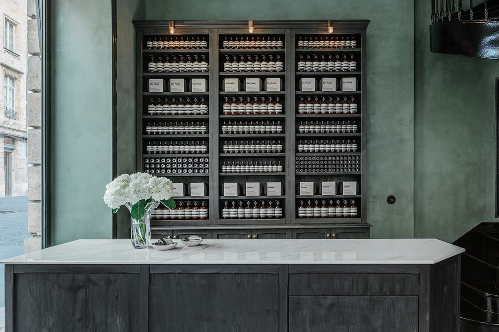 Custom green clay plaster detail at Aesop Bordeaux, applied by AG Argildesign.