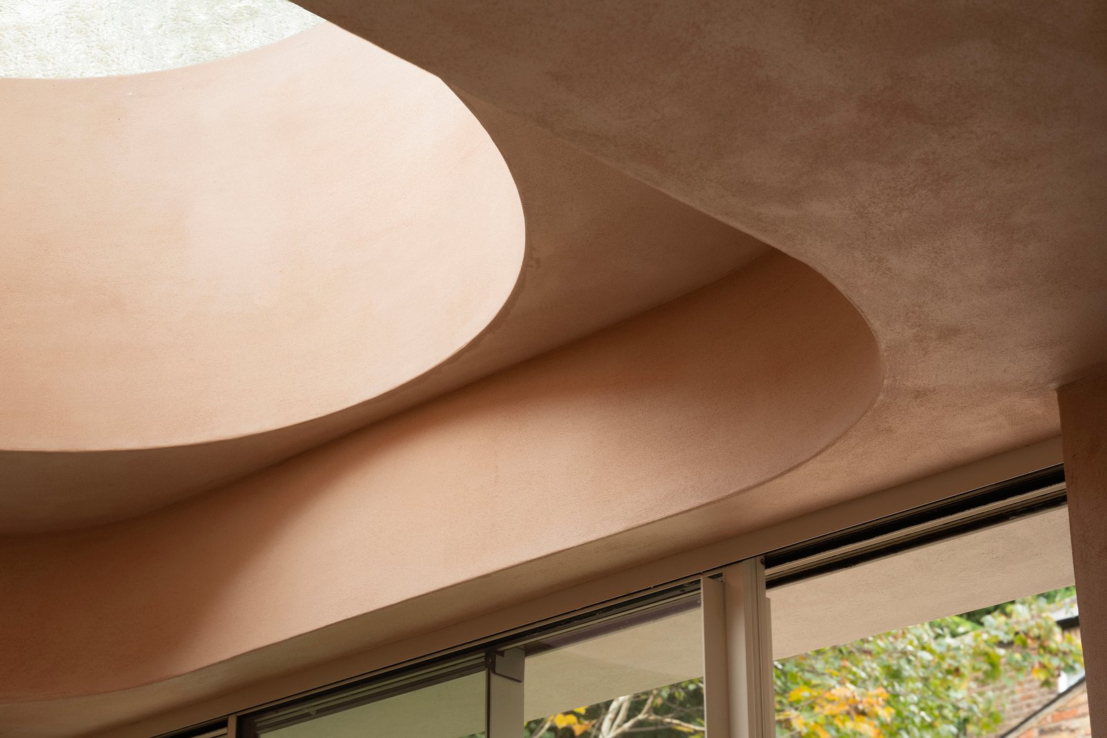 Smooth clay plaster in Nude NUD-03 against polished concrete at Balmore House, London.