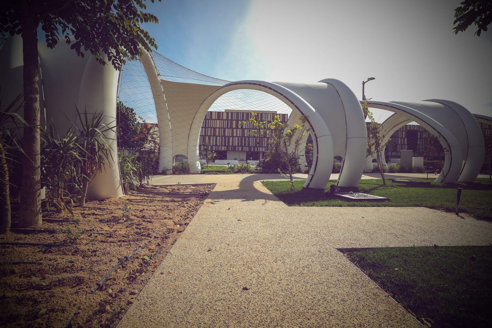 Buff Addaset resin-bound aggregate promenade leading to white arched shade canopies at Lusail Boulevard, Qatar
