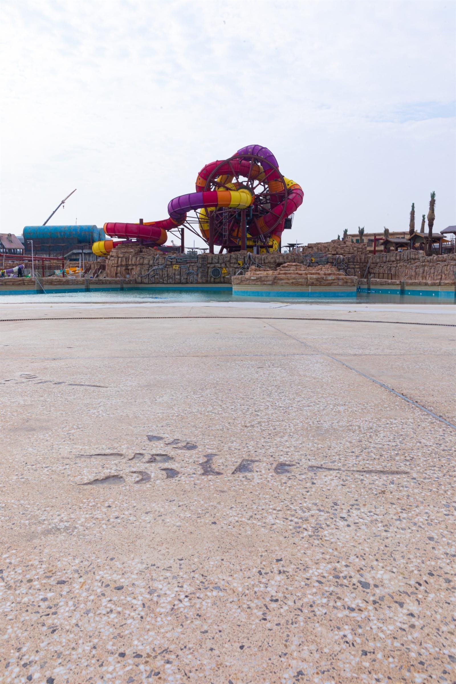 Pale sand Exposed Plus deck with imprinted dinosaur footprints, Meryal Waterpark