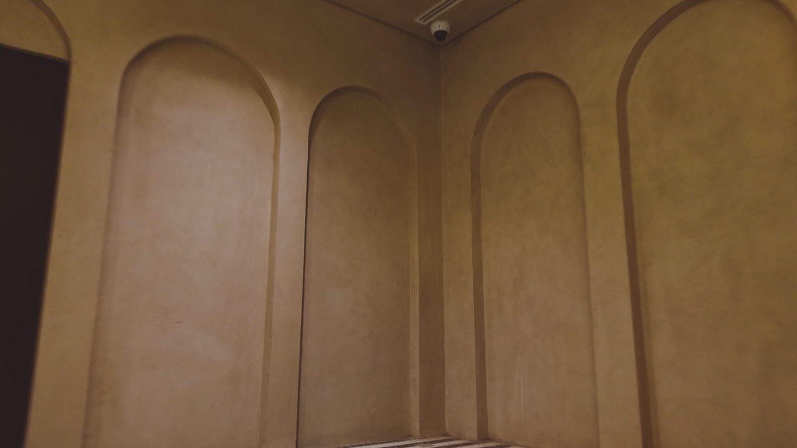Tall pointed arches finished in warm sand Microtadelakt in an arched hall at the Calligraphy Museum, Madinah