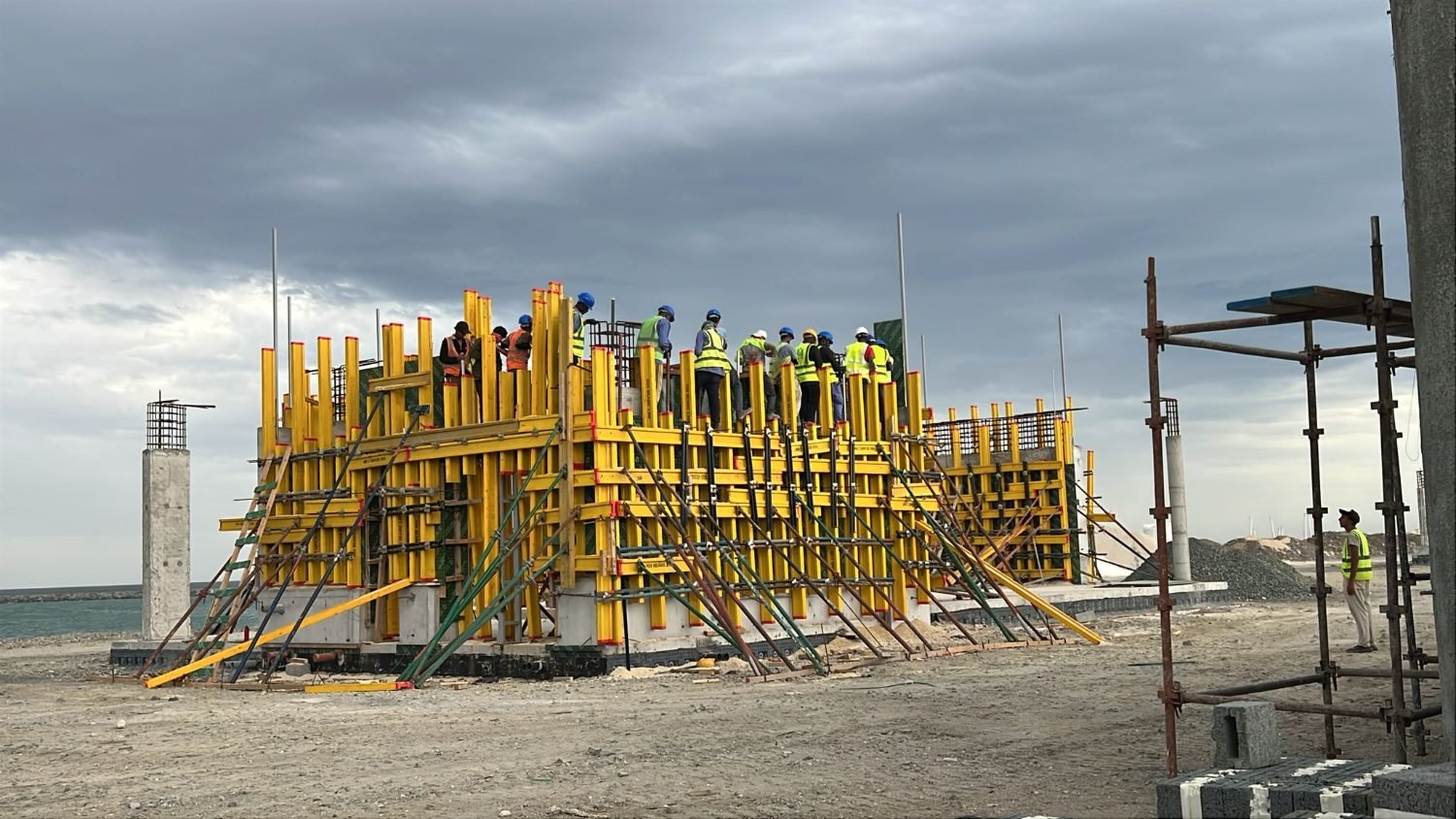 Formwork and raking props in place as crews ram the wall lifts at Kalba Beach, Sharjah
