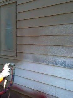 Projected cork being sprayed over painted timber cladding