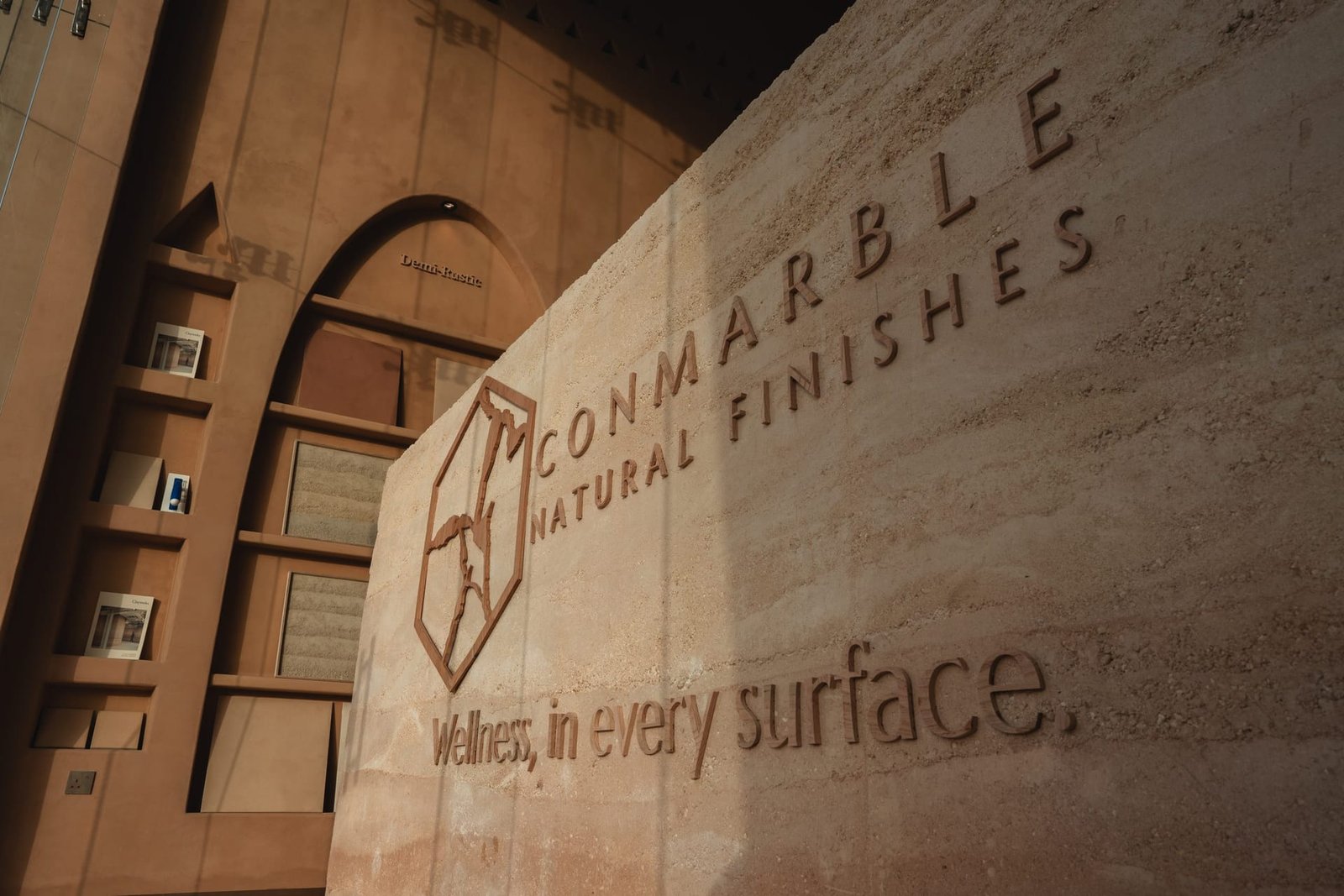 In-situ rammed earth brand wall with the slogan in relief, Conmarble showroom, Riyadh