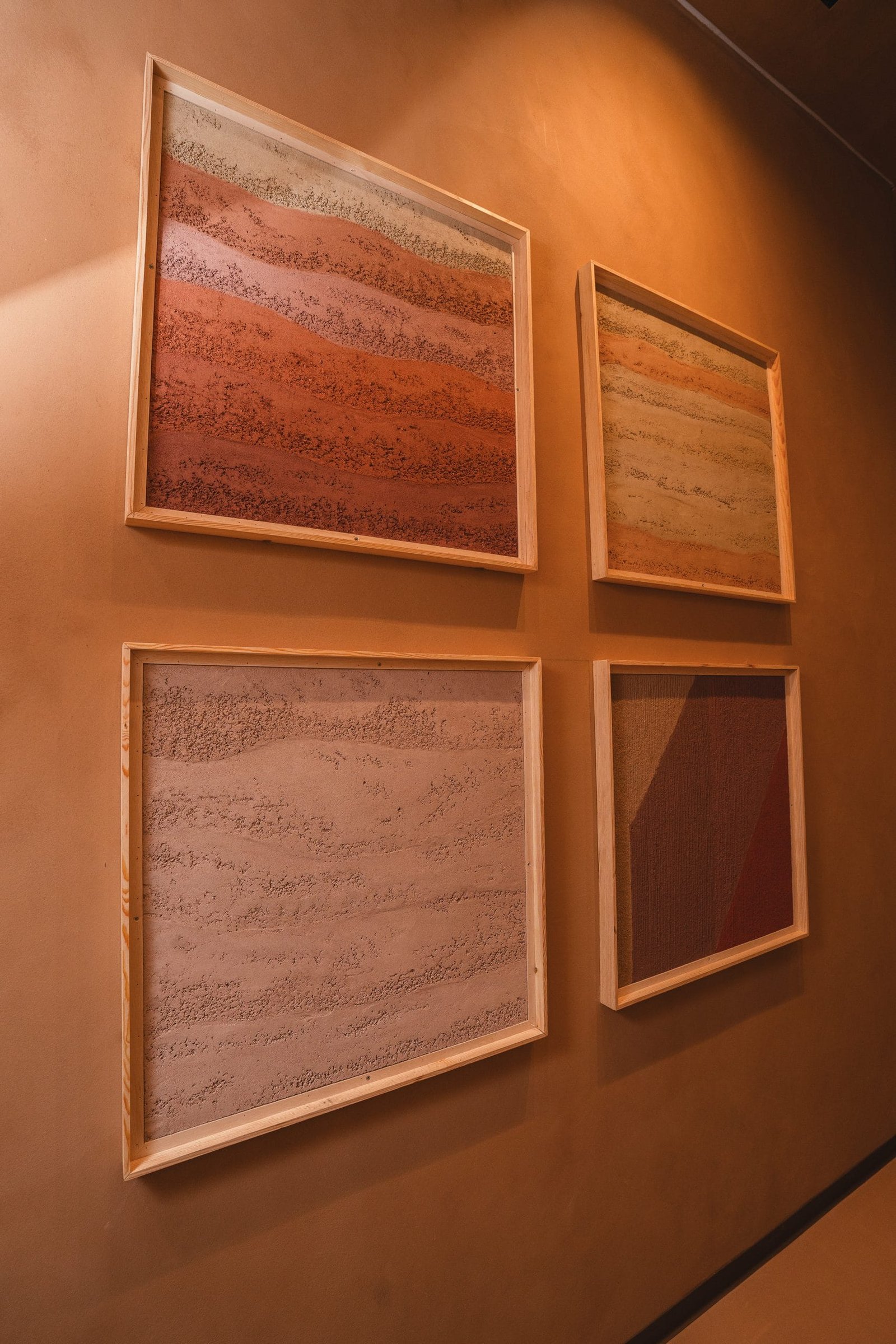 Two framed rammed earth plaster panels, cream to terracotta, at the Conmarble showroom